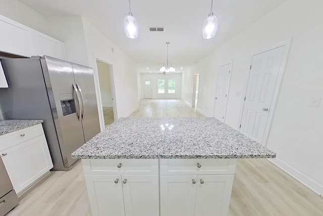 103 Heather Ln, Thomasville, GA 31792 - kitchen with light wood-style floors, stainless steel fridge with ice dispenser, a kitchen island, light stone countertops, and white cabinets