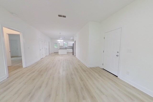 103 Heather Ln, Thomasville, GA 31792 - unfurnished living room with a chandelier, light wood finished floors, and baseboards