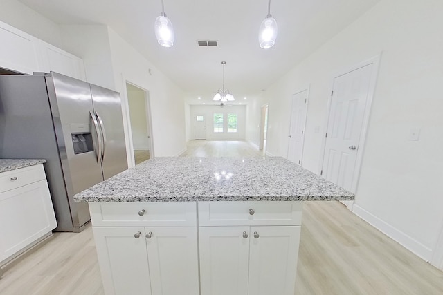 103 Heather Ln, Thomasville, GA 31792 - kitchen with stainless steel refrigerator with ice dispenser, light wood-style flooring, white cabinetry, a center island, and light stone counters