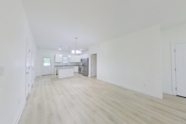 103 Heather Ln, Thomasville, GA 31792 - unfurnished living room featuring a chandelier, light wood finished floors, baseboards, and a sink