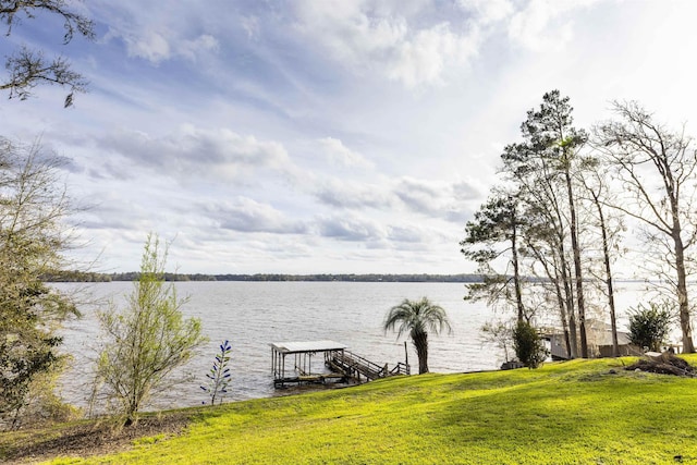 dock area with a lawn, a water view, and boat lift