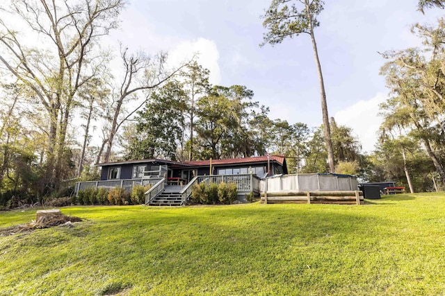 view of front of home with a deck and a front yard