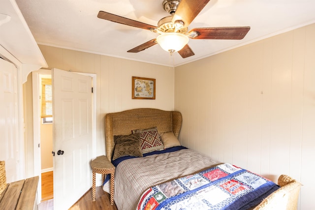 bedroom featuring crown molding, wood finished floors, and ceiling fan