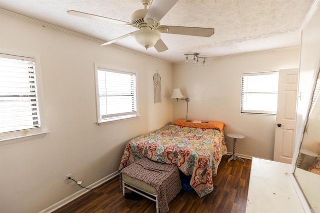 bedroom featuring baseboards, a textured ceiling, wood finished floors, and a ceiling fan