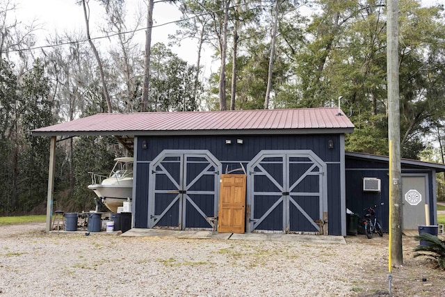 view of outbuilding featuring a wall mounted AC and an outdoor structure