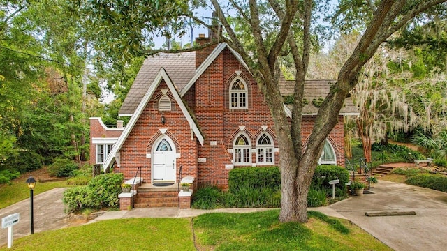 tudor-style house featuring a front yard