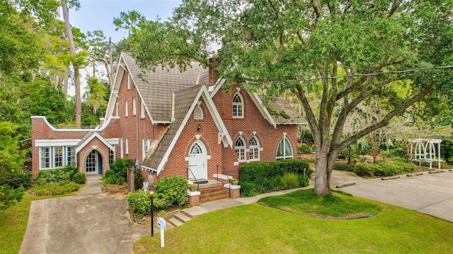 tudor home featuring a front lawn