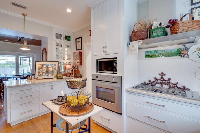 kitchen featuring visible vents, stainless steel appliances, crown molding, and white cabinets