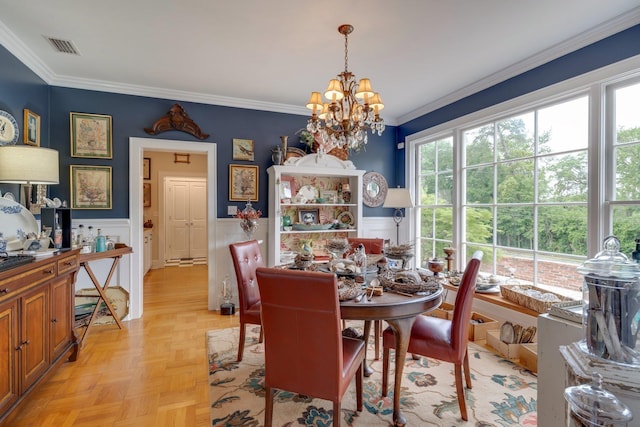 dining area with crown molding, visible vents, wainscoting, and a chandelier