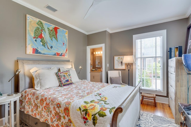 bedroom with visible vents, wood finished floors, multiple windows, and crown molding