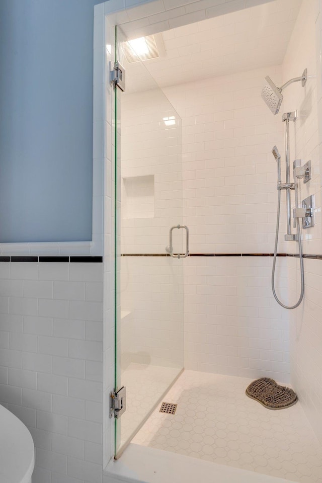 bathroom featuring toilet and a stall shower