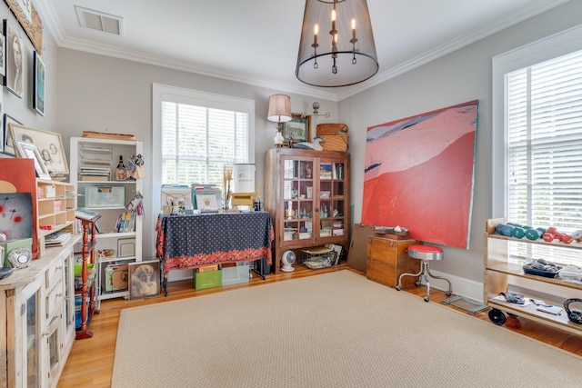interior space with ornamental molding, visible vents, wood finished floors, and a chandelier