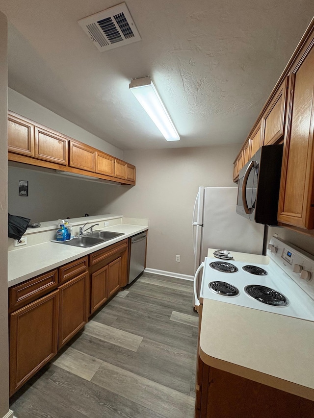 2525 Hartsfield Rd Unit 9, Tallahassee, FL 32303 - kitchen featuring stainless steel appliances, brown cabinetry, wood finished floors, and light countertops