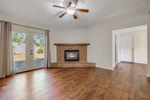 3268 Garcia Dr, Tallahassee, FL 32309 - unfurnished living room featuring french doors, wood finished floors, ceiling fan, lofted ceiling, and a brick fireplace