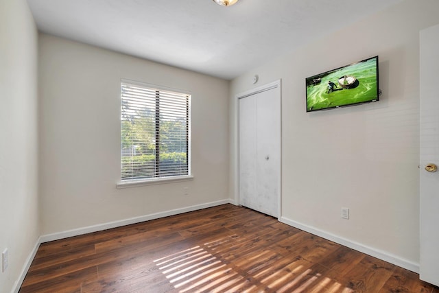 3268 Garcia Dr, Tallahassee, FL 32309 - unfurnished bedroom with dark wood-style flooring, baseboards, and a closet