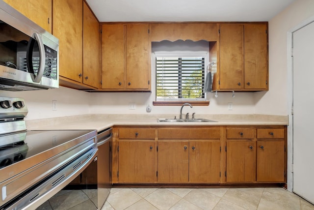 3268 Garcia Dr, Tallahassee, FL 32309 - kitchen featuring appliances with stainless steel finishes, a sink, light countertops, and brown cabinetry