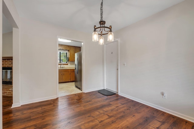 3268 Garcia Dr, Tallahassee, FL 32309 - unfurnished dining area with a sink, light wood-style floors, a chandelier, and baseboards