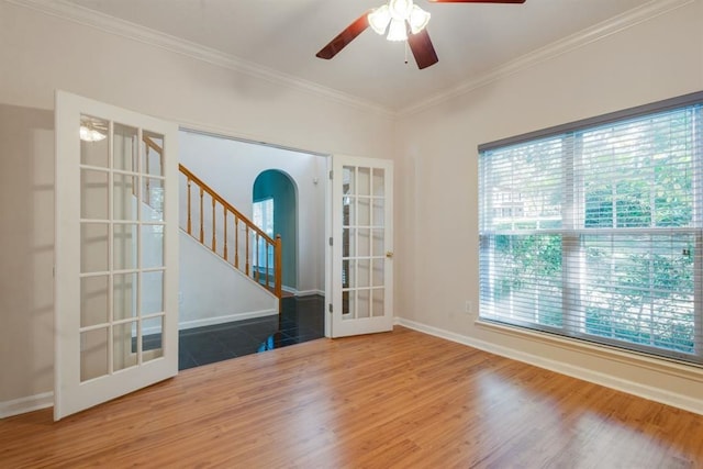 empty room with crown molding, hardwood / wood-style flooring, french doors, and ceiling fan