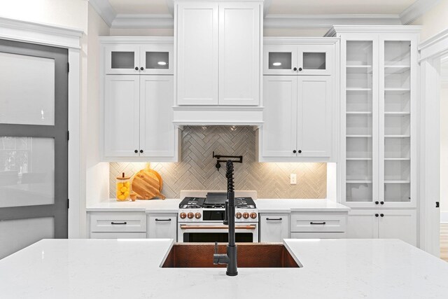 3235 Magazine Cir, Tallahassee, FL 32312 - kitchen featuring high end stove, white cabinetry, decorative backsplash, glass insert cabinets, and crown molding