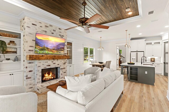 3235 Magazine Cir, Tallahassee, FL 32312 - living area featuring light wood-type flooring, crown molding, a fireplace, wood ceiling, and ceiling fan