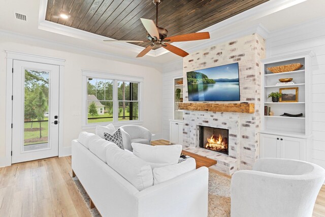 3235 Magazine Cir, Tallahassee, FL 32312 - living room with crown molding, light wood-style flooring, a brick fireplace, a ceiling fan, and a tray ceiling