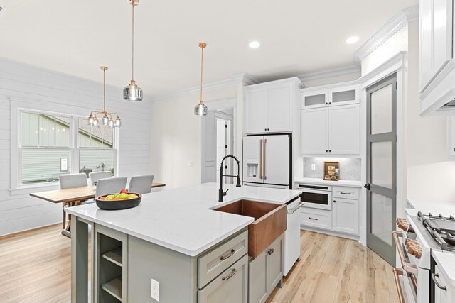 3235 Magazine Cir, Tallahassee, FL 32312 - kitchen with premium appliances, crown molding, a sink, light wood-style flooring, and a chandelier