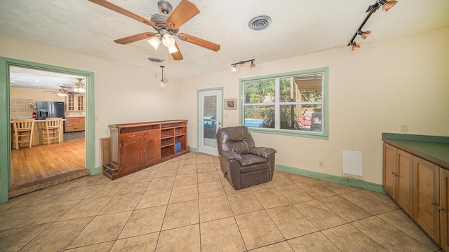 sitting room with light tile patterned floors, track lighting, and ceiling fan