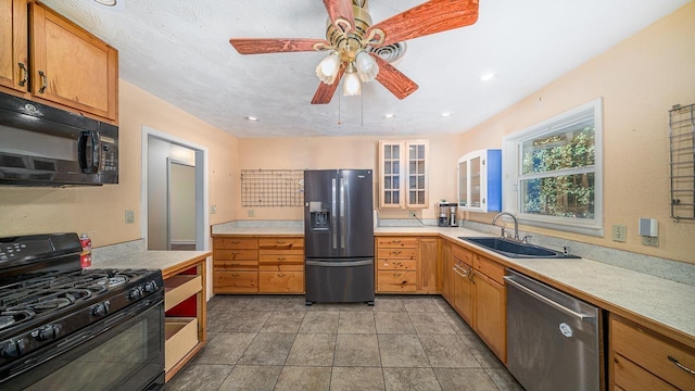 kitchen featuring sink, light tile patterned floors, black appliances, and ceiling fan