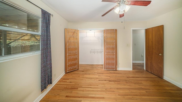 interior space featuring a walk in closet, light hardwood / wood-style flooring, a closet, and ceiling fan