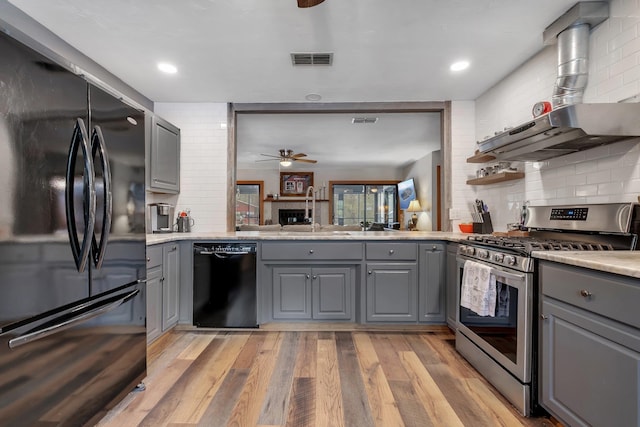 kitchen featuring gray cabinetry, sink, light hardwood / wood-style flooring, and black appliances