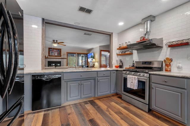 kitchen featuring gray cabinetry, dark hardwood / wood-style floors, backsplash, and black appliances