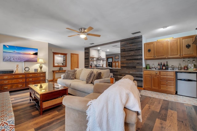 living room with ceiling fan, bar, and dark hardwood / wood-style flooring