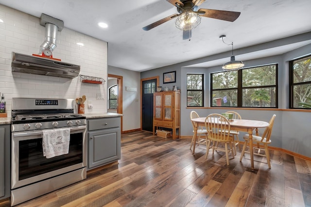 kitchen featuring gray cabinets, dark hardwood / wood-style flooring, decorative backsplash, light stone counters, and gas stove