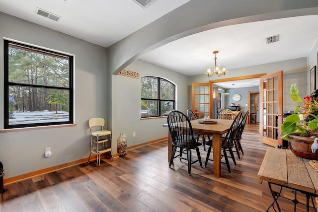 dining space featuring a notable chandelier, dark hardwood / wood-style floors, plenty of natural light, and french doors