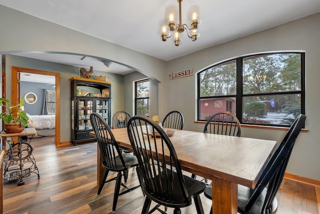 376 Tecumseh Rd, Monticello, FL 32344 - dining area with an inviting chandelier, arched walkways, baseboards, and wood finished floors