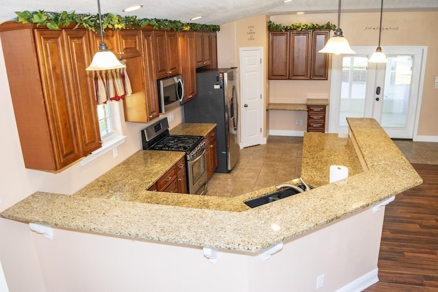 21 Blenheim Rd Fl, Shalimar, FL 32579 - kitchen with kitchen peninsula, appliances with stainless steel finishes, hanging light fixtures, and a breakfast bar area