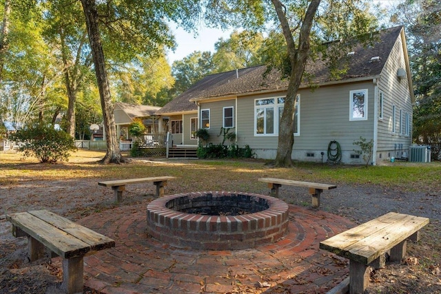 rear view of property with a patio, a deck, central air condition unit, and a fire pit