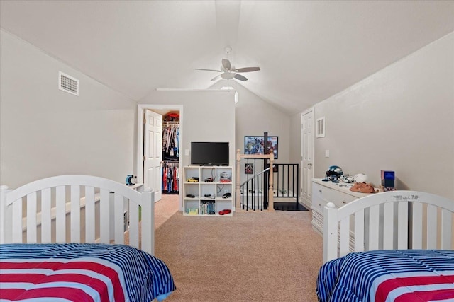 bedroom with a spacious closet, vaulted ceiling, carpet flooring, a closet, and ceiling fan