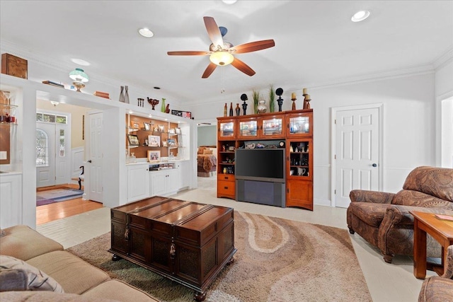 living room with crown molding and ceiling fan