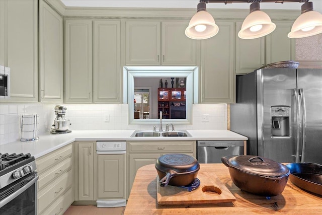 kitchen with stainless steel appliances, sink, hanging light fixtures, and backsplash