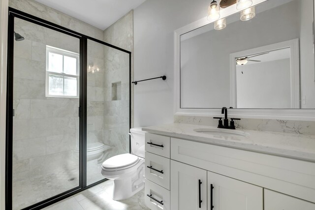 bathroom featuring vanity, a ceiling fan, toilet, and a shower stall