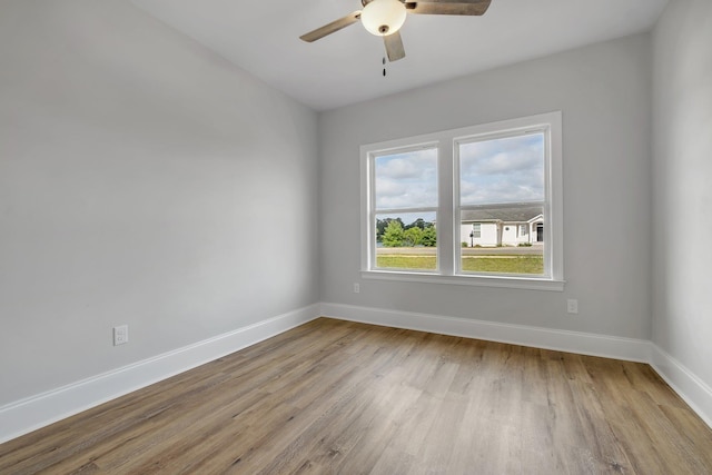empty room with baseboards, a ceiling fan, and wood finished floors