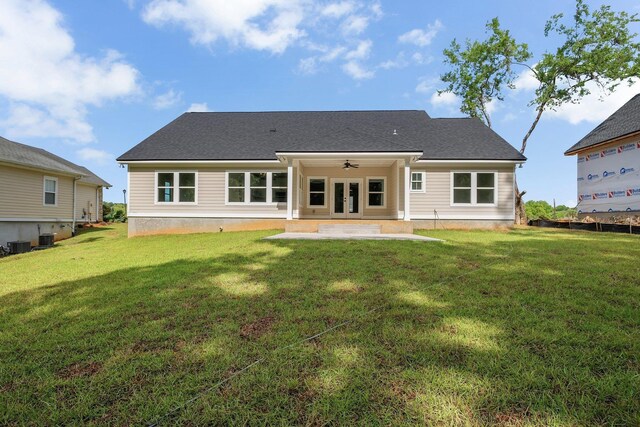 rear view of property featuring a lawn, ceiling fan, french doors, and a patio