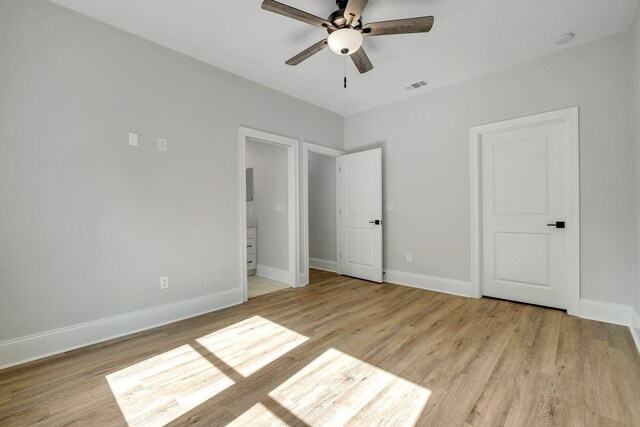 unfurnished bedroom featuring baseboards, visible vents, and wood finished floors
