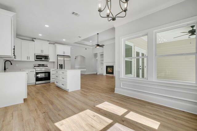 kitchen with open floor plan, recessed lighting, a sink, ceiling fan with notable chandelier, and stainless steel appliances