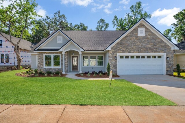 craftsman inspired home with concrete driveway, a front lawn, stone siding, and a garage