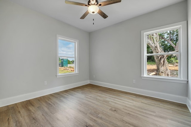 spare room with baseboards, a ceiling fan, and light wood-style flooring