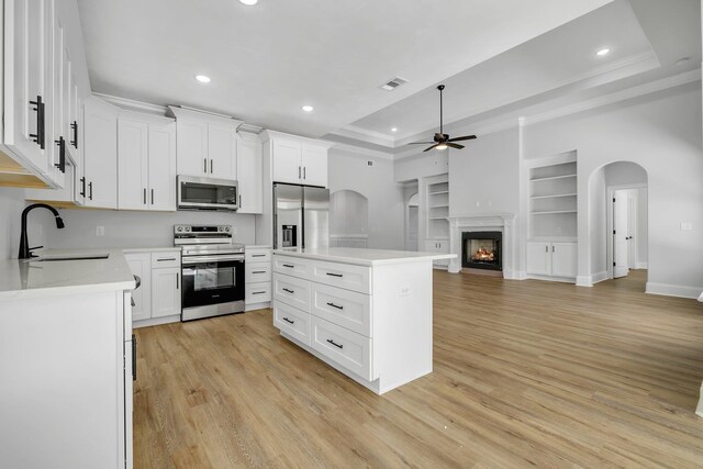kitchen featuring ceiling fan, appliances with stainless steel finishes, a sink, built in shelves, and visible vents