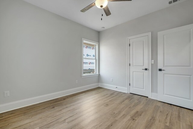unfurnished bedroom with baseboards, a ceiling fan, light wood finished floors, and visible vents