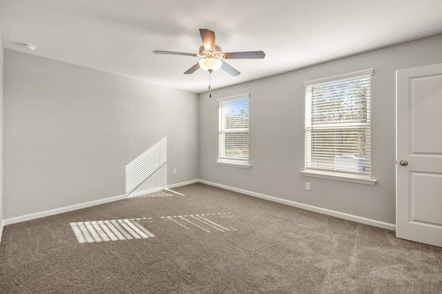 carpeted spare room with ceiling fan